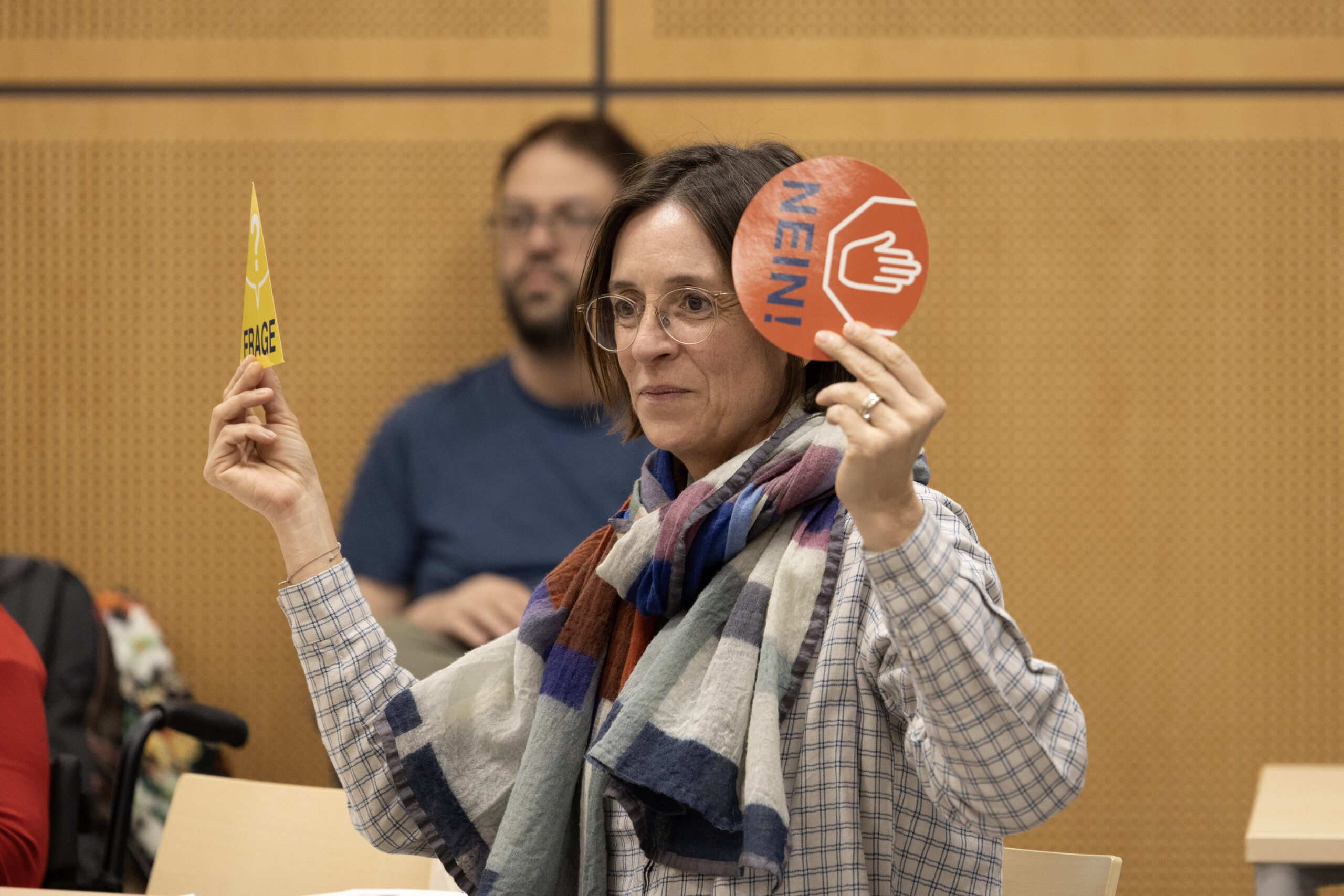Eine Frau hält jeweils in einer Hand ein kleines Schild mit der Aufschrift ja und Nein.