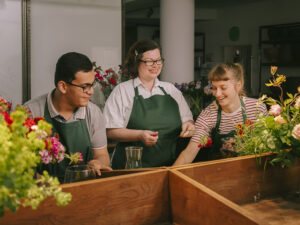 Drei Personen in einer Gärtnerei.